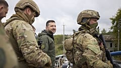 Ukrainian President Volodymyr Zelenskyy, center, is surrounded by soldiers during his visit in Izium, Kharkiv region, Ukraine, Sept. 14, 2022.