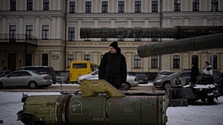 Egy férfi egy orosz rakéta maradványait nézi Kijev központjában 2023. február 7-én
