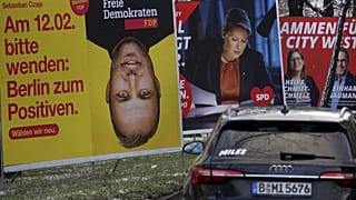 Cars drive past election campaign posters in Berlin, Germany, Feb. 6, 2023.