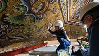 Restorers Chiara Zizola, right, and Roberto Nardi work at the restoration of the mosaics that adorn the dome of one of the oldest churches in Florence, St. John's Baptistery.