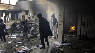 متظاهرون يتجمعون في مركز للشرطة أضرمت فيه النيران بعد أن احتشد الآلاف للمطالبة بتسليم الضباط رجلاً متهمًا بحرق المصحف، شارسادا، في ولاية خيبر بختونخوا- 29 نوفمبر 2021.