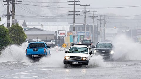 Cars move through flooded roads in the northern New Zealand city of Whangarei as Tropical Cyclone Gabrielle hits the Northland, Sunday, Feb. 12, 2023.