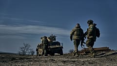 سربازان ارتش اوکراین در حال حرکت به سمت خودروی زرهی «هامِر» آمریکایی در موقعیتی نزدیک باهموت. شنبه، یازدهم فوریه ۲۰۲۳.