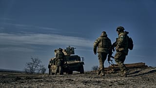 سربازان ارتش اوکراین در حال حرکت به سمت خودروی زرهی «هامِر» آمریکایی در موقعیتی نزدیک باهموت. شنبه، یازدهم فوریه ۲۰۲۳.