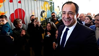 Presidential candidate Nikos Christodoulides smiles as walks with his supporters after casting his vote during the presidential elections, February 12 2023