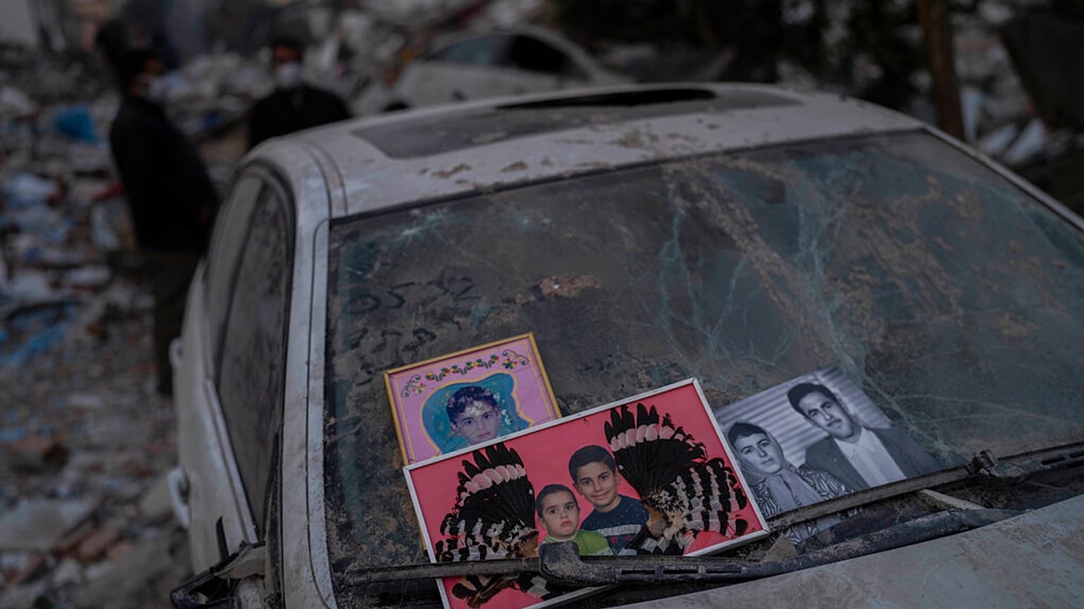 Imagens recuperadas dos escombros de um edifício destruído durante terramoto são colocadas num para-brisas de um carro em Antakya, no sudeste da Turquia