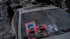 Imagens recuperadas dos escombros de um edifício destruído durante terramoto são colocadas num para-brisas de um carro em Antakya, no sudeste da Turquia
