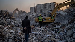A man stands on top of the rubble of his house destroyed during an earthquake in Antakya, southeastern Turkey.