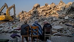 Un grupo de mujeres ante su casa destruída