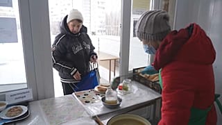  Volunteers give out food to residents in Saltivka. 