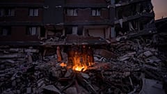 Une famille se réchauffe devant l'immeuble où elle a perdu cinq membres à Antakya, Turquie, 12.02.2023.