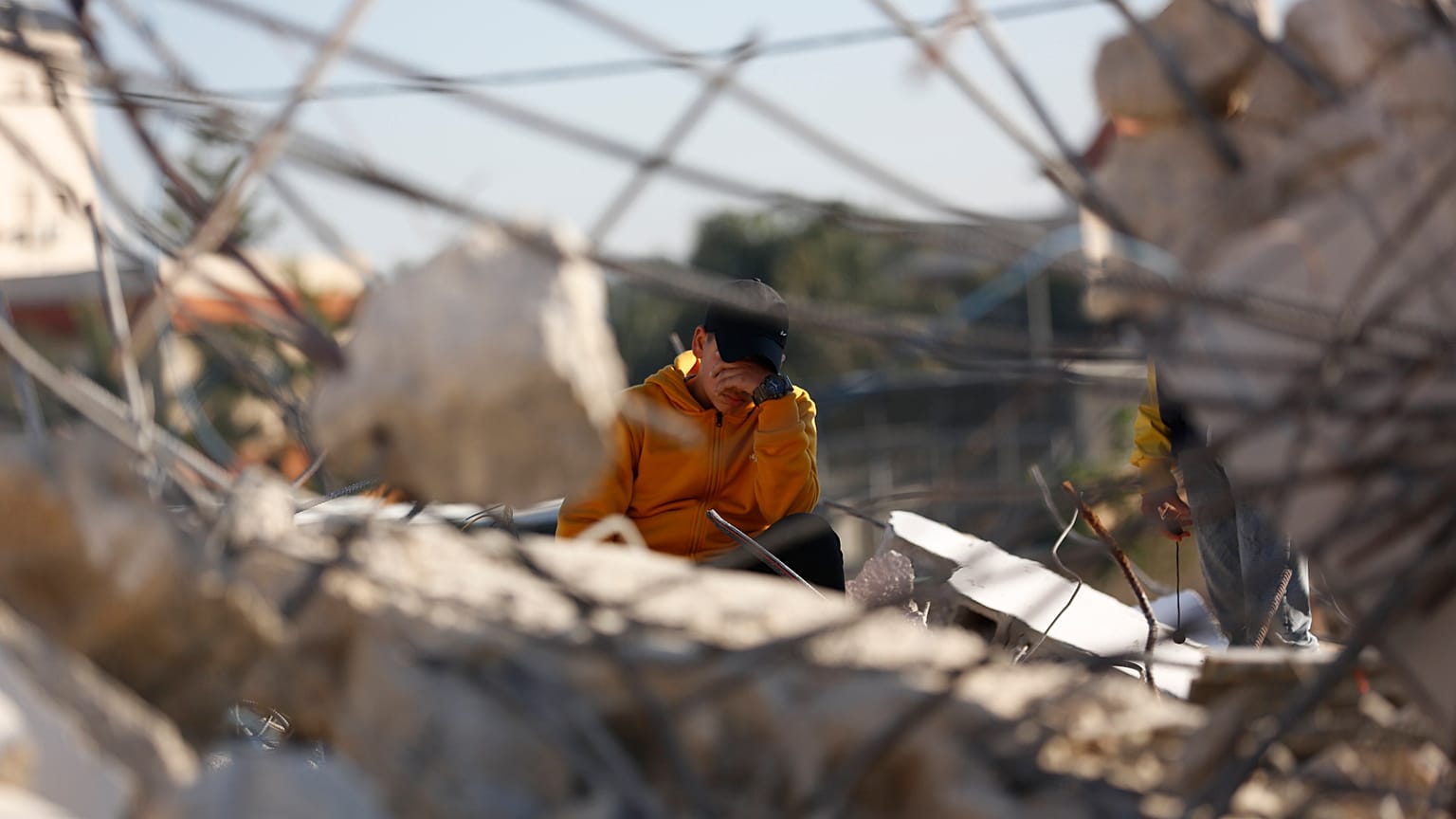 فتى فلسطيني على أنقاض منزله بعد أن دمره الجيش الإسرائيلي في مدينة جنين الضفة الغربية.
