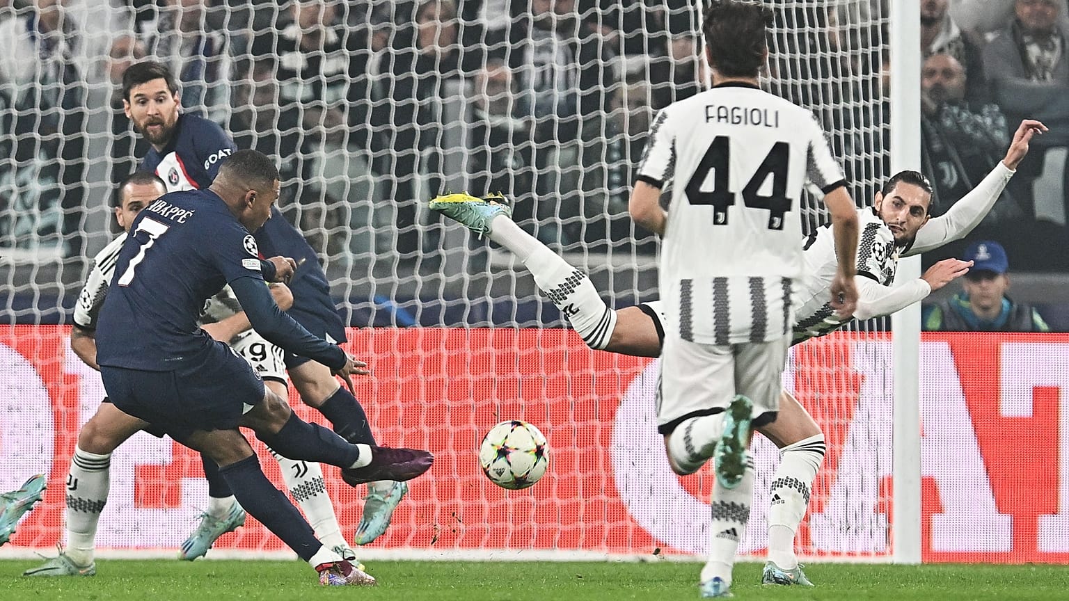 A PSG játékosa, Kylian Mbappe (7) gólt lő a Juventus elleni BL-találkozón, csapattársa, Lionel Messi igyekszik elugrani a labda elől Torinóban 2022. november 2-án.