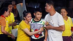 Duangpetch Promthepet (középen), az elárasztott barlangból kimentett egyik fiút a rokonai köszöntik otthonában, Thaiföldön, Chiang Rai tartományban, 2018. július 18-án..