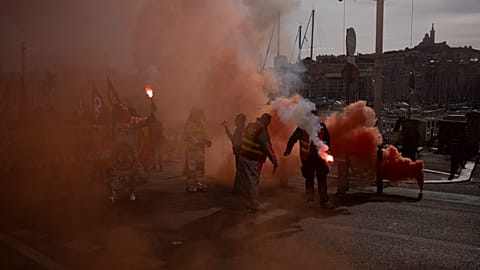 Protesters light flares during a demonstration in Marseille, southern France,