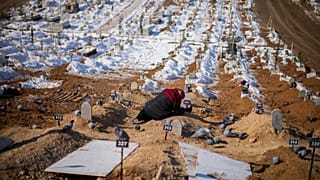 Une femme pleure sur la tombe de son fils et sa fille tués dans le tremblement de terre du 6 février dans le cimetière de Malatya en Turquie, le 12 février 2023