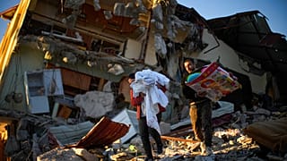 Die wenigen Habseligkeiten, die sie unter den Trümmern finden, bringen diese beiden Männer in der türkischen Erdbebenregion in ihre Übergangsunterbringung.