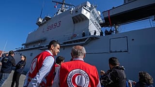 Members of the Syrian Arab Red Crescent oversee the unloading of containers of aid from the Italian Navy ship San Marco in the port of Beirut, Lebanon, 17 February 2023.