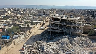 صورة جوية تظهر جرارا يزبل حطام مبنى منهار في بلدة جندريس، 15 فبراير 2023.