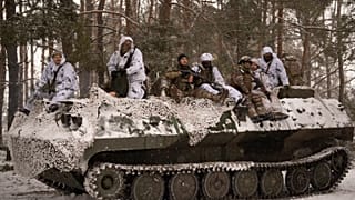 Ukrainische Soldaten außerhalb von Kupiansk auf einem gepanzerten Transporter zur Front