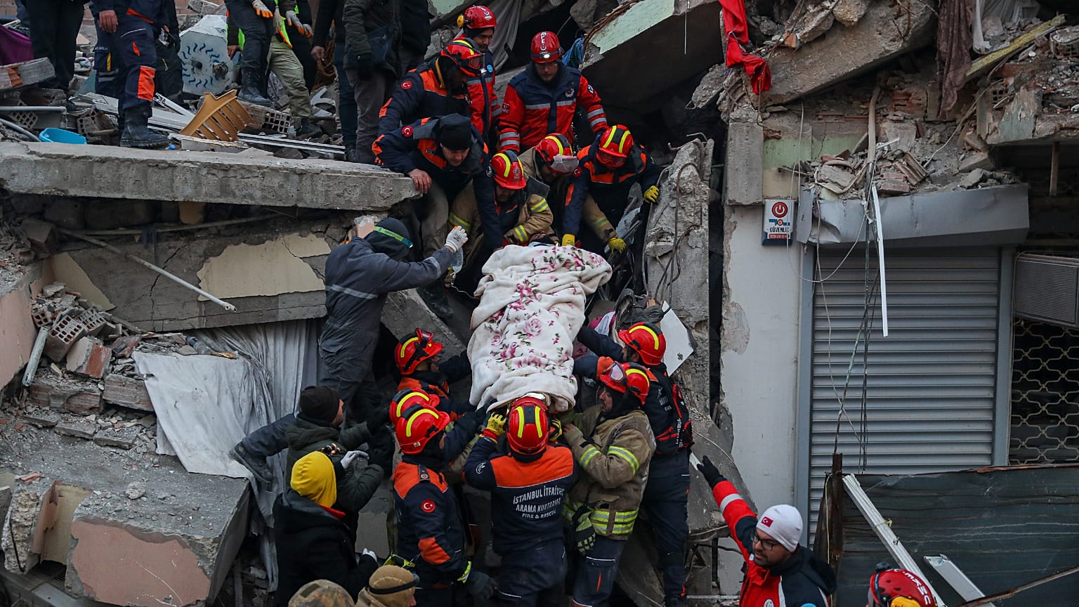Turkish rescue workers carry a man to an ambulance after they pulled him out from a collapsed building.