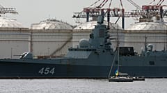 Лодка с украинским флагом на фоне фрегата "Адмирал Горшков" в порту Кейптауна, ЮАР