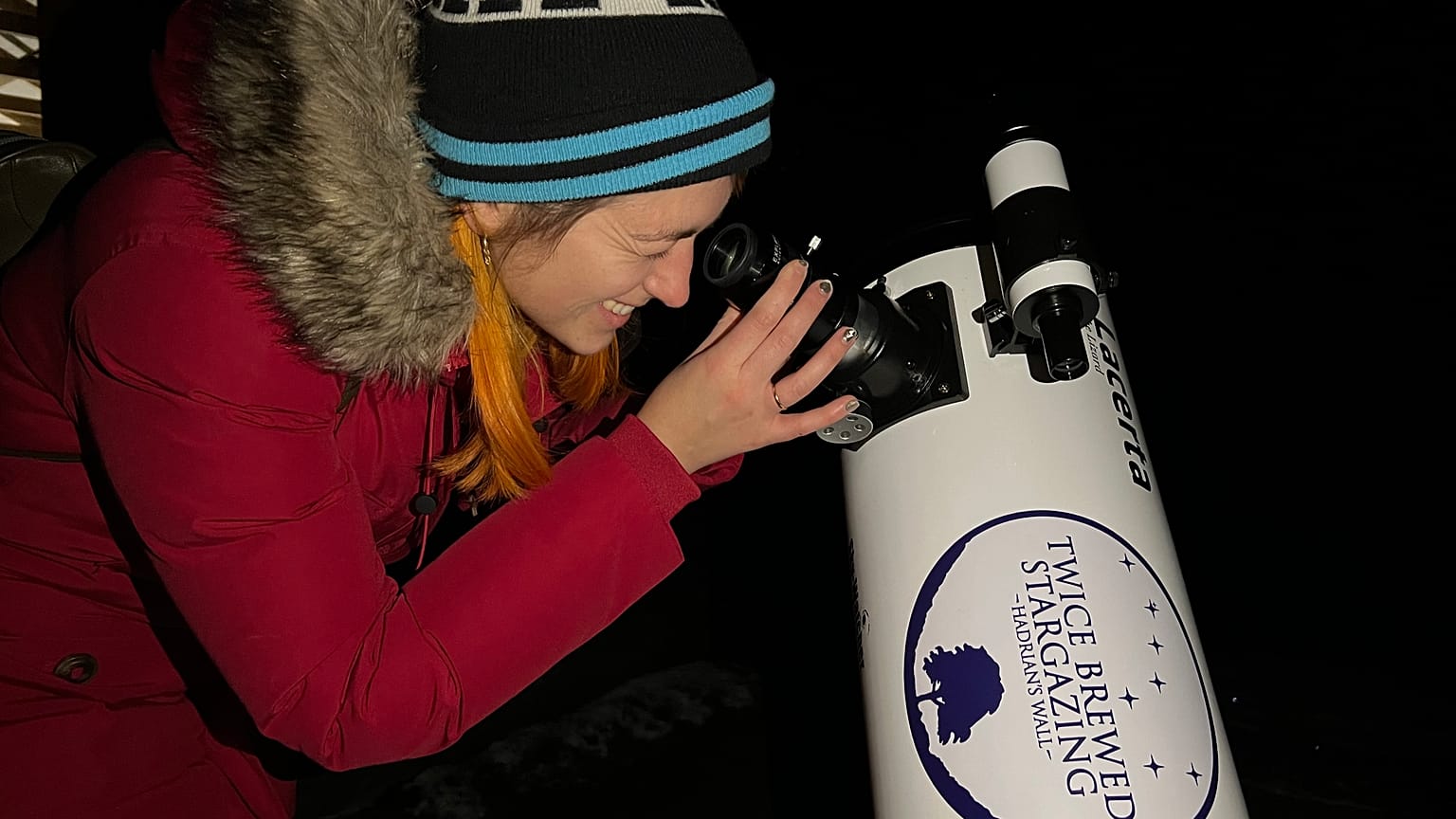 Euronews Travel journalist Hannah Brown looking through a telescope