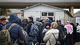 Syrians wait to cross into Syria from Turkey at the Cilvegozu border gate, near the town of Antakya, southeastern Turkey, Tuesday, Feb. 21, 2023.