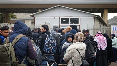 Syrians wait to cross into Syria from Turkey at the Cilvegozu border gate, near the town of Antakya, southeastern Turkey, Tuesday, Feb. 21, 2023.