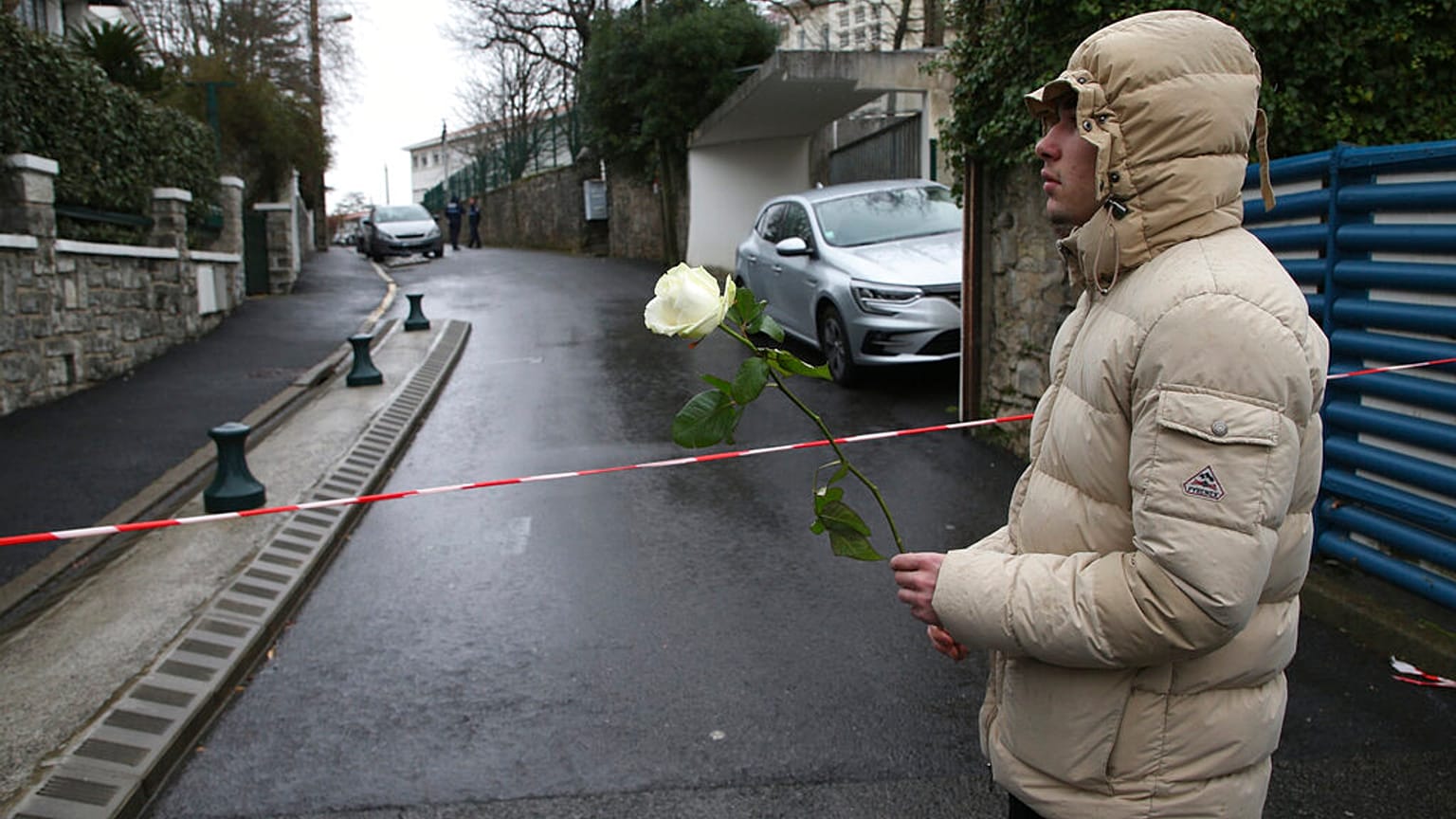 A youth holds a white rose at the entrance of a private Catholic school after a teacher of Spanish has been stabbed to death by a high school student, Wednesday, Feb. 22, 2023