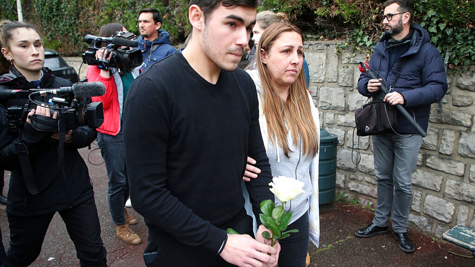 Mourners arrive with a rose at the entrance of a private school in France after a teacher was stabbed to death by a high school student on Wednesday morning.