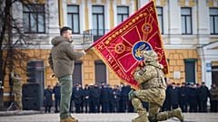 Президент Украины Владимир Зеленский c флагом воинской части в ходе церемонии в Киеве 24 фквраля 2023 г.