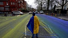 Протестующий c флагом  Украины на проезжей части, разрисованной в цвета краинского флага
