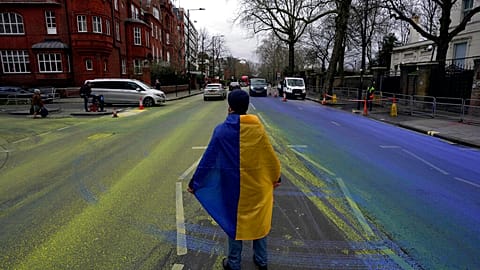 Протестующий c флагом  Украины на проезжей части, разрисованной в цвета краинского флага