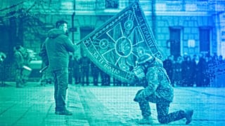Ukrainian President Volodymyr Zelenskyy holds the flag of a military unit as an officer kisses it in Kyiv, 24 February 2023