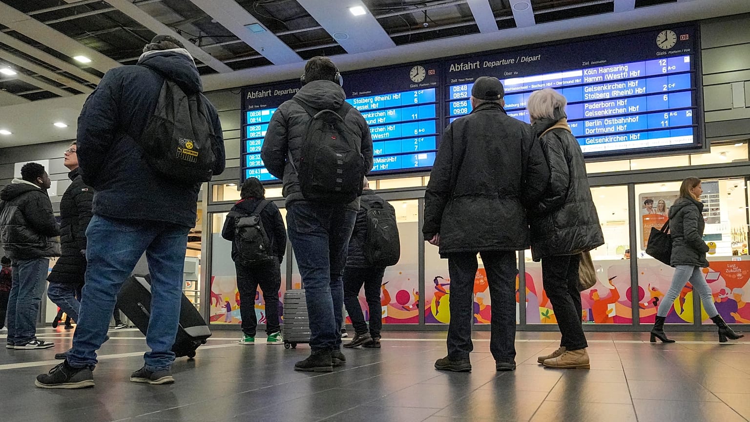Reisende betrachten einen Informationsbildschirm am Hauptbahnhof in Essen, Deutschland, als die meisten Züge am Donnerstag, 16. November 2023, ausfielen.