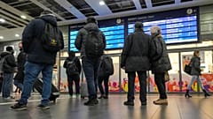 Reisende betrachten einen Informationsbildschirm am Hauptbahnhof in Essen, Deutschland, als die meisten Züge am Donnerstag, 16. November 2023, ausfielen.