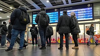 Reisende betrachten einen Informationsbildschirm am Hauptbahnhof in Essen, Deutschland, als die meisten Züge am Donnerstag, 16. November 2023, ausfielen.