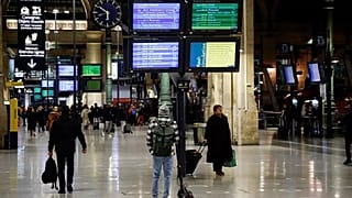 Travellers walks at Gare du Nord train station in Paris on a new day of nationwide strikes and protests against the government's pension reform plan on March 23.