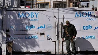 یک محافظ خصوصی افغان از در ورودی اصلی تلویزیون طلوع در کابل، افغانستان محافظت می‌کند