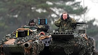 German Defense Minister Boris Pistorius, right, sits on a Leopard 2 tank