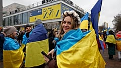 Eine Demonstrantin hat sich vor dem Berliner "Cafe Moskau" in eine ukrainische Flagge gewickelt.