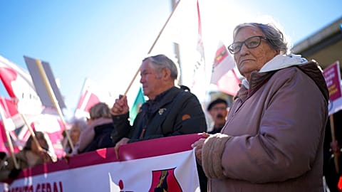 Pensioners hold a banner with the words "General Increase" during a demonstration protesting the rise of the cost of living