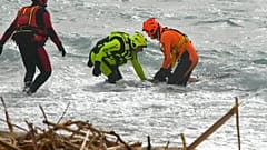 Des secouristes sur une plage près de Cutro, Italie, le 26 février 2023