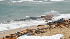 Un cuerpo y los restos de una embarcación volcada en una playa cerca de Cutro, en el sur de Italia, el domingo 26 de febrero de 2023.