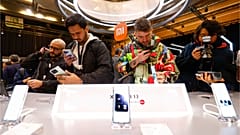 Visitors take pictures of Xiaomi 13 mobile phone models at the Xiaomi booth before the Mobile World Congress 2023 in Barcelona, Spain, on Sunday, Feb. 26, 2023