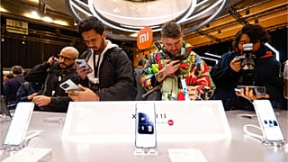 Visitors take pictures of Xiaomi 13 mobile phone models at the Xiaomi booth before the Mobile World Congress 2023 in Barcelona, Spain, on Sunday, Feb. 26, 2023