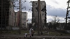 Lányok sétálnak a Kijevhez közeli Irpin szétlőtt házai között