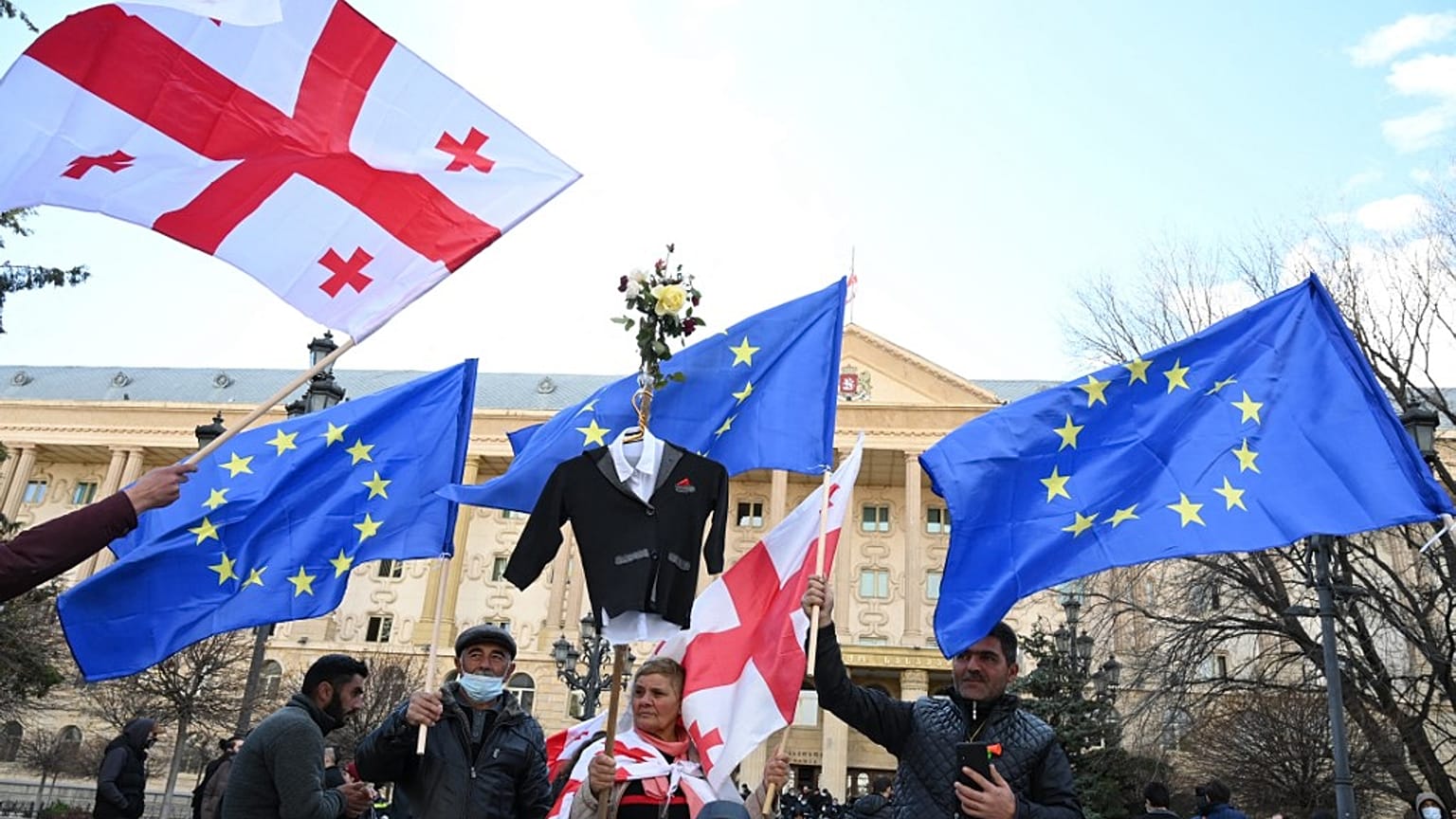 People waves European and Georgian national flags as they gather outside Tbilisi's city court on December 2, 2021.