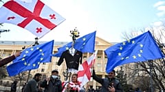 People waves European and Georgian national flags as they gather outside Tbilisi's city court on December 2, 2021.